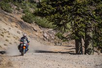 Hombre en motocicletas de turismo conduciendo por carretera de grava en Argentina - foto de stock