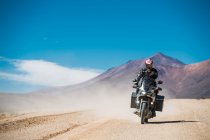 Mann mit Tourenmotorrad auf staubiger Straße in Bolivien — Stockfoto