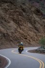 Mulher em turnê de moto equitação torção estrada na Argentina — Fotografia de Stock
