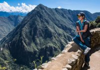 Donna appoggiata sul muro a secco sul sentiero Inca vicino a Machu Picchu — Foto stock