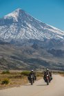Пара на гастрольных мотоциклах. Вулкан Ланин в задней части, Аргентина — стоковое фото
