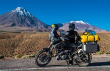 Donna dietro la moto ADV, davanti allo stratovolcano Licancabur — Foto stock