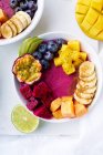 Ciotole di frutta vista dall'alto per una colazione sana. Ciotole di frullato Pitaya con mango e frutta estiva — Foto stock