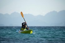 One woman paddling on a seat on top kayak close to the shore of Carmen Island in Loreto, Baja California, Mexico. — Stock Photo