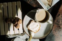 Schuss von oben von einem leckeren Stück Brot mit Butter und Marmelade auf dem Tisch mit Walnüssen und frischem Kaffee — Stockfoto