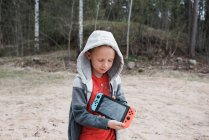 Niño sosteniendo una consola de juegos Nintendo compartiendo la pantalla - foto de stock