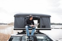 Mann arbeitet vom Zelt aus mit Blick auf soziale Distanz zum Büro — Stockfoto
