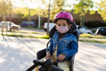 Маленька дівчинка в масці для обличчя готова до їзди на велосипеді — стокове фото
