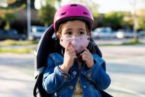 Petite fille portant un masque facial prêt pour une balade à vélo — Photo de stock