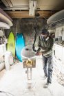 Young man making surfing board. — Stock Photo