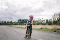 Accompagnatrice ragazza imparare a skateboard da sola — Foto stock