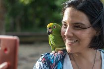 Mujer realiza una selfie con un loro en la selva del Delta del Orinoco en Venezuela - foto de stock