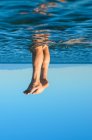 Junge männliche Beine, die aus dem Wasser kommen. Surrealismus — Stockfoto