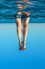 Молодые мужские ноги выходят из воды. Сюрреализм — стоковое фото
