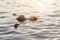 Mujer joven flotando en la espalda en el mar - foto de stock