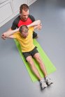 Personal Trainer hilft Klient im Fitnessstudio — Stockfoto