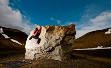 Женщина валунами на скале в сельской местности Исландии — стоковое фото