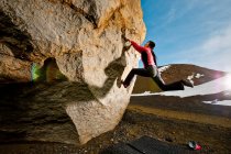 Frau bouldert auf Felsen im ländlichen Island — Stockfoto