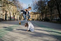 Возбужденные девочка и мальчик играют на улице — стоковое фото