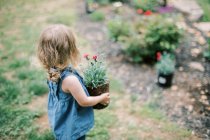 Little girl with  pink flowers in garden — Stock Photo