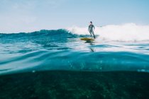 Surfista femenina surfeando una pequeña ola - foto de stock