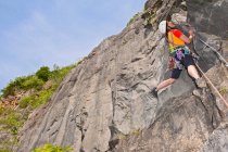 Mujer escalando acantilado de piedra caliza en Gales del Sur - foto de stock