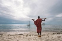 Uomo con zaino sulla spiaggia — Foto stock