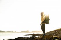 Tiro de uma mulher explorando o litoral com mochila — Fotografia de Stock