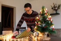 Jeune homme emballe cadeaux de Noël pour les amis et la famille — Photo de stock