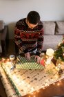 Jeune homme emballe cadeaux de Noël pour les amis et la famille — Photo de stock
