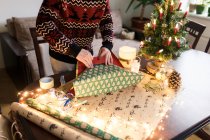 Молодой человек собирает рождественские подарки для друзей и семьи — стоковое фото