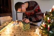 Young man packs Christmas presents for friends and family — Stock Photo