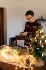 Uomo scattare foto su smartphone accuratamente avvolto regalo di Natale — Foto stock