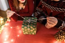Pareja joven enamorada de los regalos de Navidad en un ambiente festivo - foto de stock