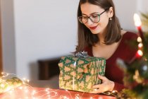 Jovem mulher milenar com presentes de Natal em uma atmosfera festiva — Fotografia de Stock