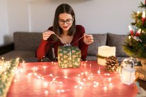 Young millennial woman with christmas presents in a festive atmosphere — Stock Photo