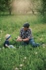 Un padre e un figlio che giocano in un campo di dente di leone — Foto stock