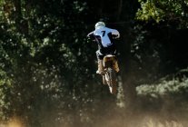 Motocross number 7 jumping with dust — Stock Photo