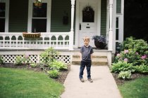Un enfant de cinq ans posant pour un portrait devant sa porte — Photo de stock