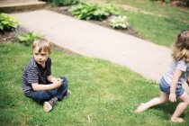 Irmãos brincando no jardim — Fotografia de Stock