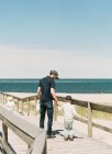 Um pai segurando seu filho pela mão na praia — Fotografia de Stock
