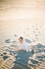 Una niñita jugando en la playa - foto de stock