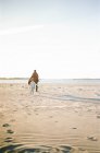Un ragazzino e suo padre giocano a tag in spiaggia — Foto stock