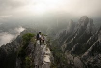 Молодой человек карабкается на скалистые горы — стоковое фото