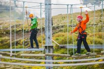 Два чоловіки, що балансують на високому шляху канатної перешкоди в Ісландії — стокове фото