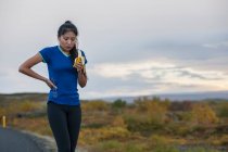 Schöne Frau isst Banane während der Arbeit im ländlichen Raum in Island — Stockfoto