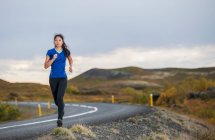 Красива жінка біжить по сільській місцевості в Ісландії. — стокове фото