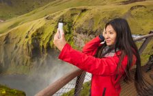 Bela mulher tomando selfie em Skogarfoss cachoeira na Islândia — Fotografia de Stock