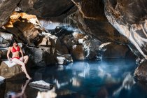 Donna seduta alla grotta di Grjotgja nel nord dell'Islanda — Foto stock