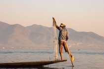 Рибалка балансує і рибалить під час заходу сонця — стокове фото